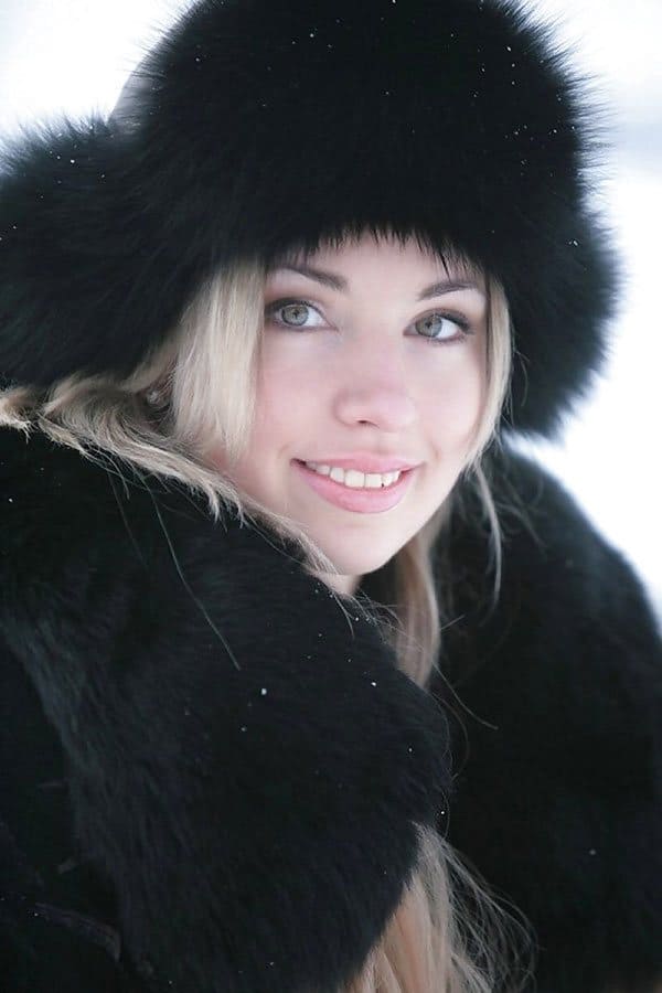 Русская красна девица гуляет зимой по деревне в шубе на голое тело и шапке ушанке 1 фото