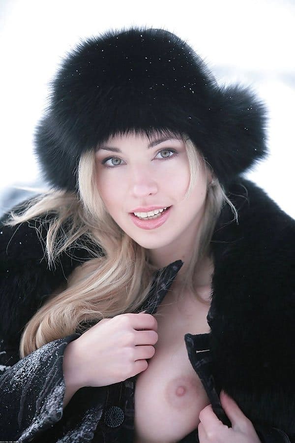 Русская красна девица гуляет зимой по деревне в шубе на голое тело и шапке ушанке 2 фото