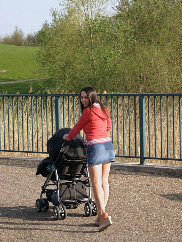 Молоденькая мамашка гуляет с коляской в мини юбке без лифчика и трусиков 1 фото