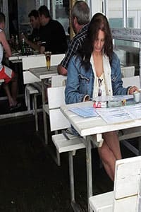 Женщина без трусиков под юбкой обедает в кафе