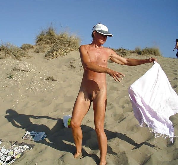 Голая нудистка писает на пляже 15 фото