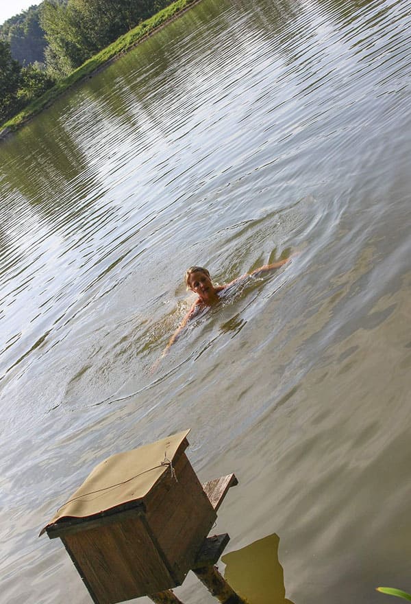 Веселая нудистка ныряет с тарзанки в озеро 1 фото