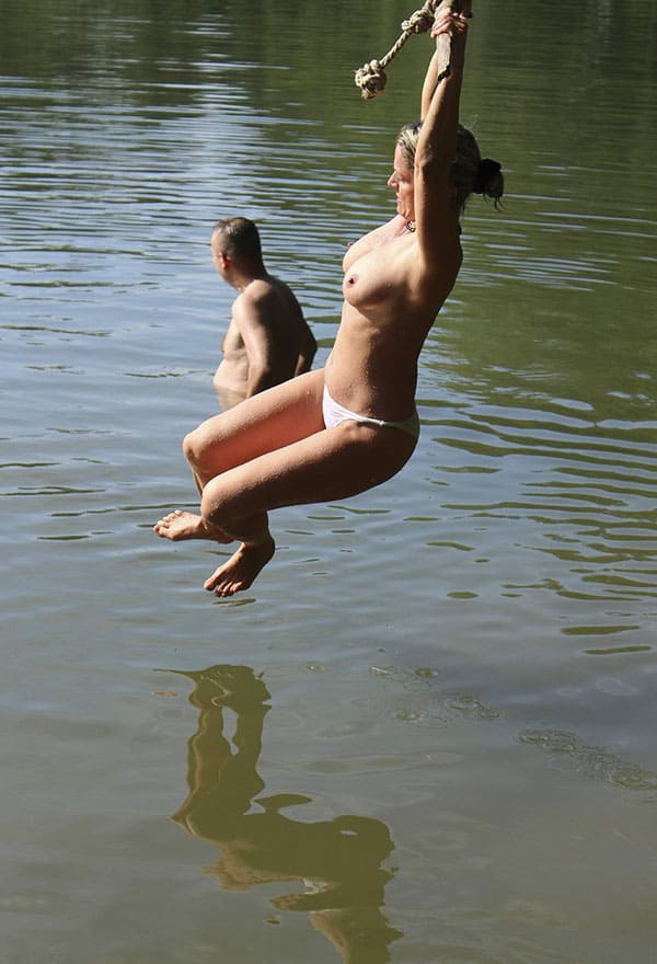 Веселая нудистка ныряет с тарзанки в озеро 11 фото