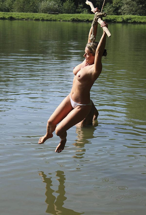 Веселая нудистка ныряет с тарзанки в озеро 12 фото