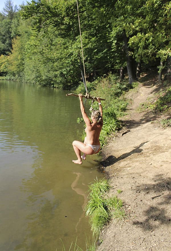 Веселая нудистка ныряет с тарзанки в озеро 3 фото