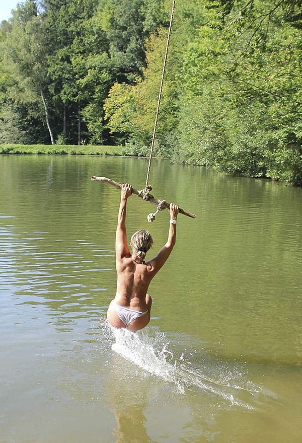 Веселая нудистка ныряет с тарзанки в озеро 4 фото