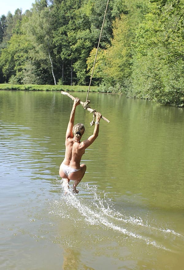Веселая нудистка ныряет с тарзанки в озеро 5 фото