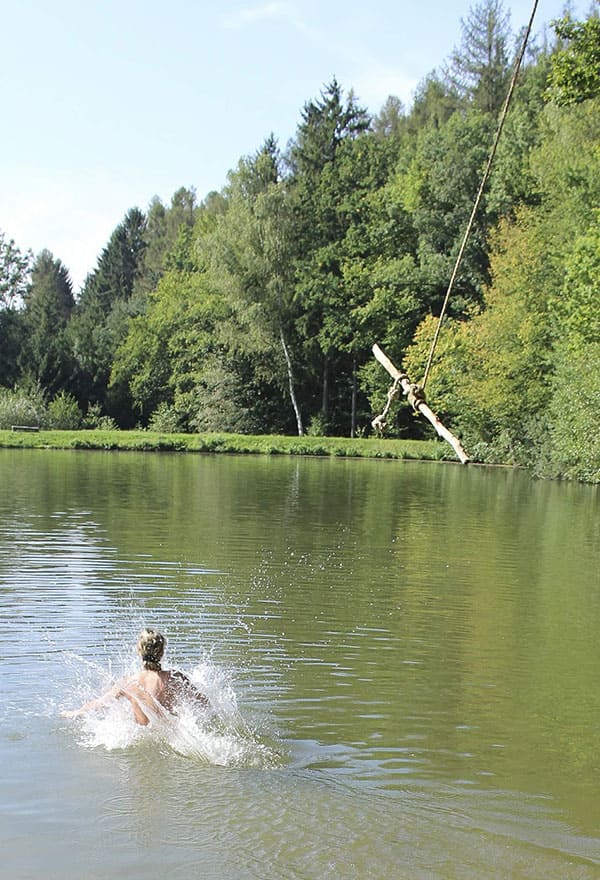 Веселая нудистка ныряет с тарзанки в озеро 8 фото