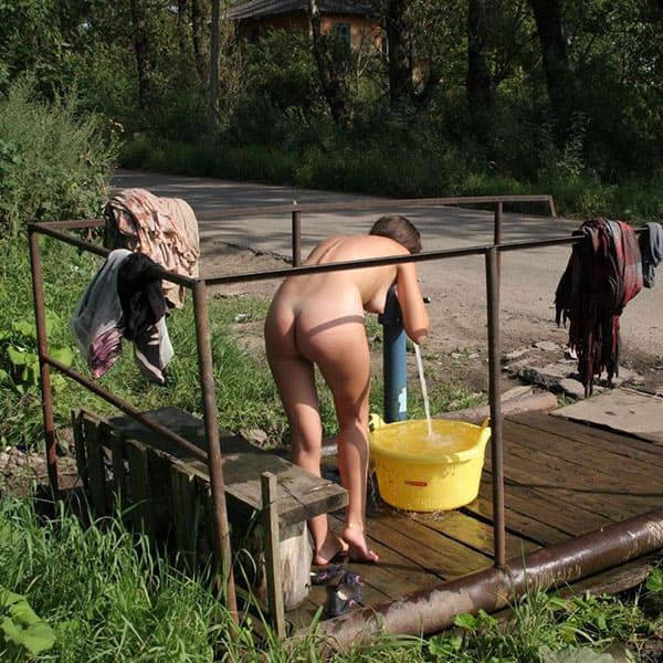 Голая девушка моется на деревенской улице 3 фото