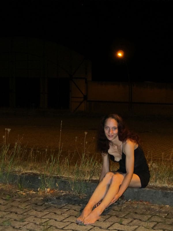 Худая брюнетка в вечернем платье обножила маленькую грудь сидя на тротуаре