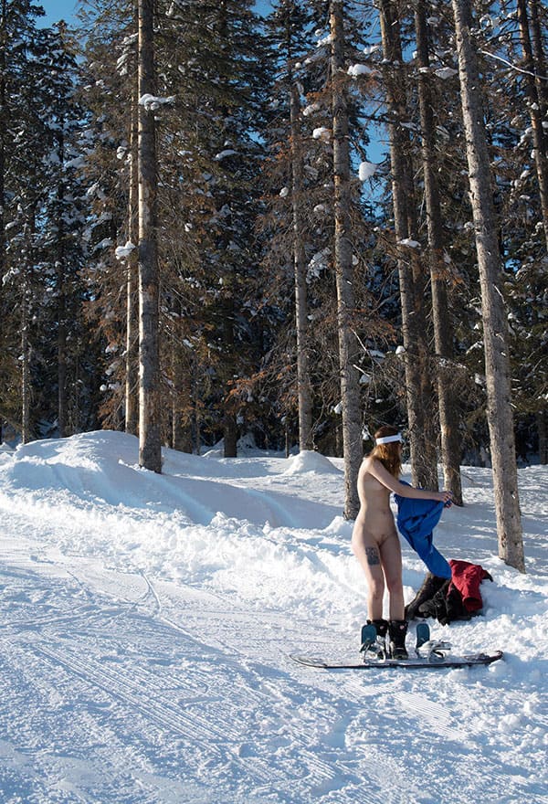 Голая девушка катается на сноуборде зимой 5 фото