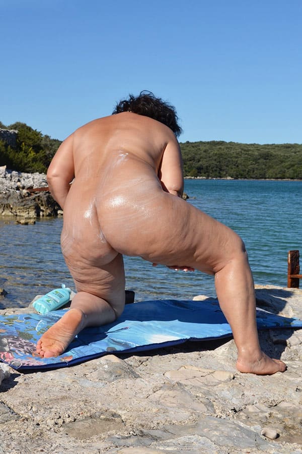 Толстая женщина мажет себя кремом на пляже 21 фото