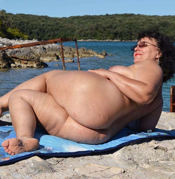 Толстая женщина мажет себя кремом на пляже 49 фото