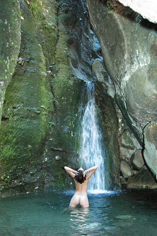Молодая нудистка купается под водопадом 3 фото