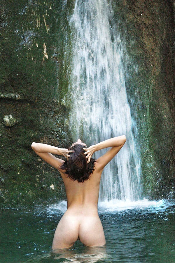 Молодая нудистка купается под водопадом 4 фото