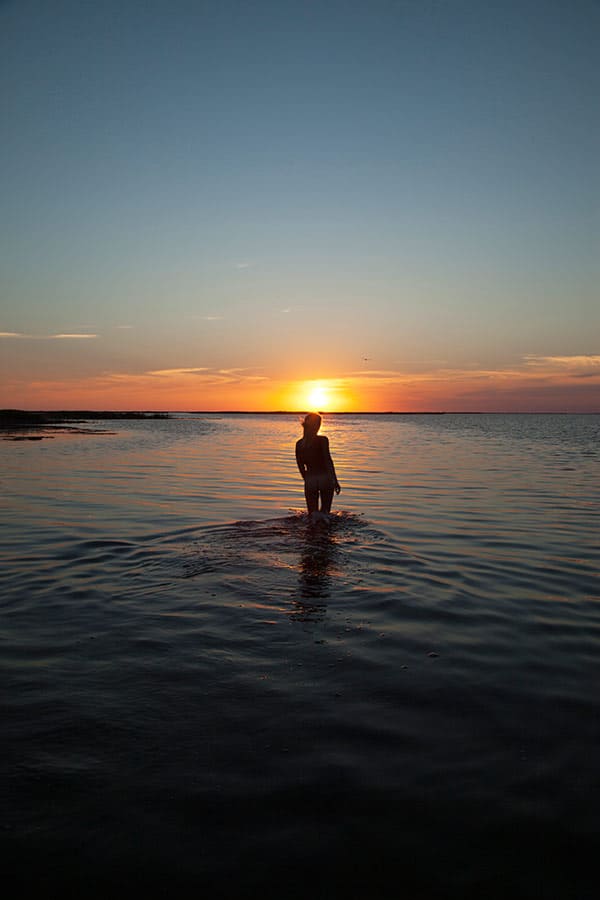 Молодая нудистка купается на закате 106 фото