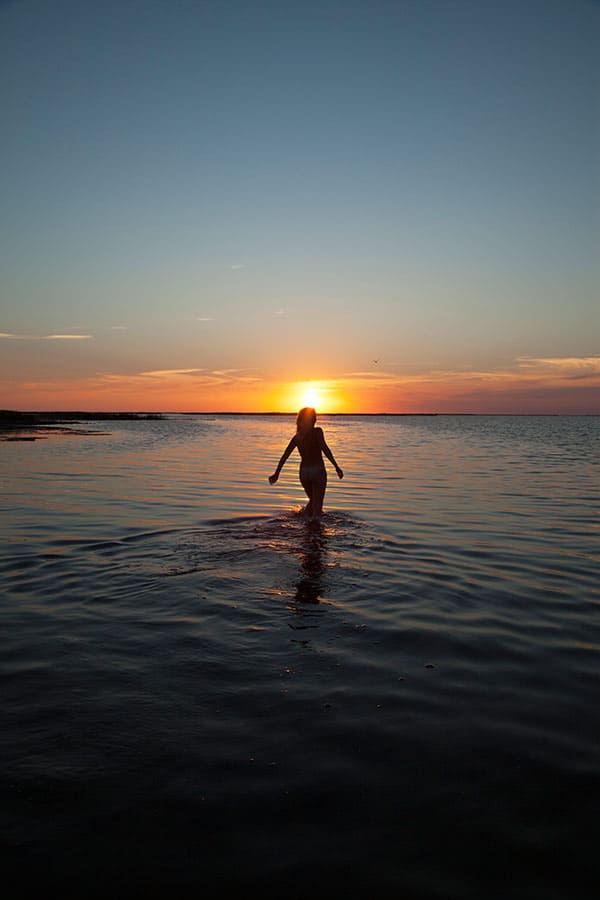 Молодая нудистка купается на закате 107 фото