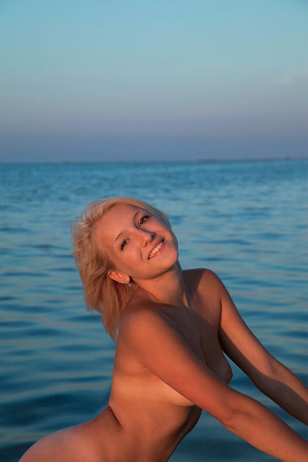 Молодая нудистка купается на закате 68 фото