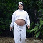 Беременная девушка гуляет на улице с голым животом