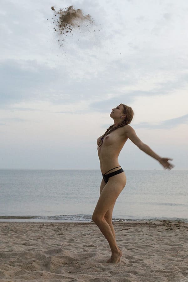 Молодая нудисточка в песке 6 фото