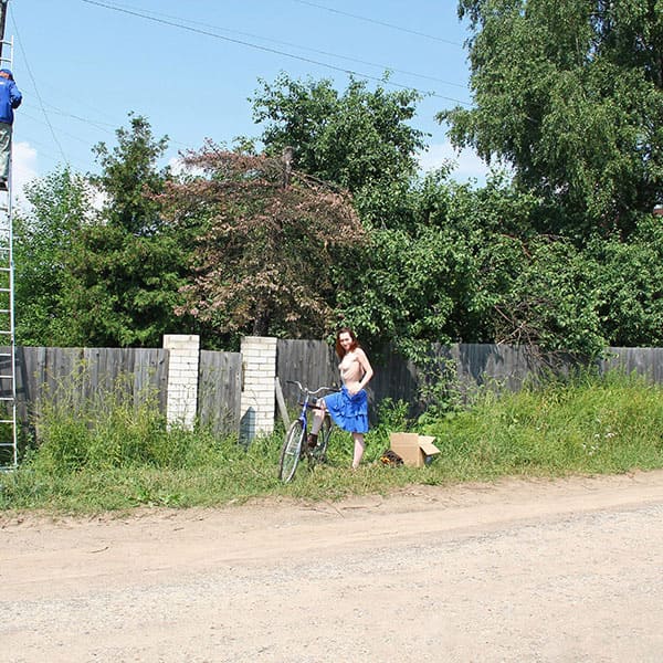 Голая женщина катается на велосипеде по посёлку 5 фото