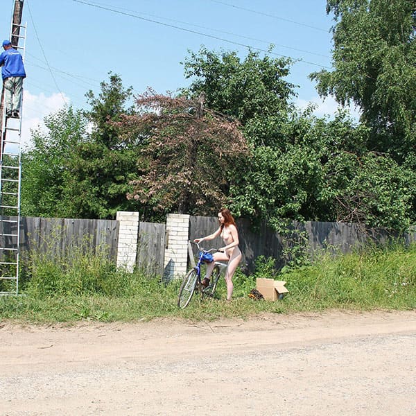 Голая женщина катается на велосипеде по посёлку 7 фото