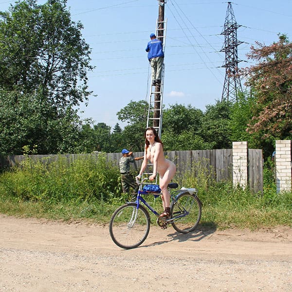 Голая женщина катается на велосипеде по посёлку 9 фото
